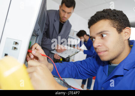 Giovane tecnico utilizzando il multimetro Foto Stock