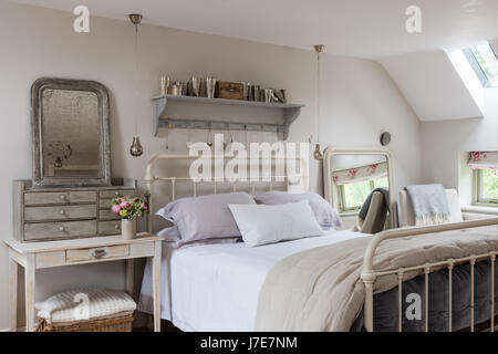 Letto di ferro battuto da piuma & nero nella sensazione rustica camera da letto con le pareti dipinte di scrematura di pietra da Farrow & Ball Foto Stock