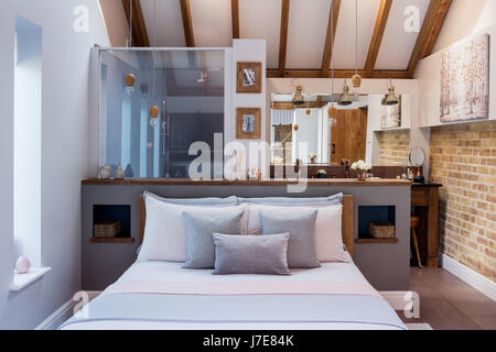 Boutique chic camera da letto con un luminoso germoglio luci in legno da Nordic Tales. L'armadio dietro il letto è dipinto in una mole di respiro da parte Farrow & Ball e Foto Stock