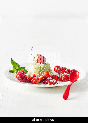 Matcha panna cotta con stawberries e scaglie di cocco Foto Stock