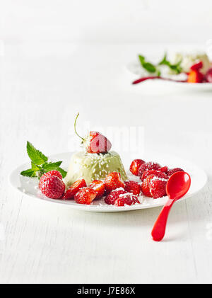 Matcha panna cotta con stawberries e scaglie di cocco Foto Stock