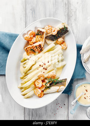 Asparagi con salmone, baccalà, gamberi e salsa hollandaise Foto Stock