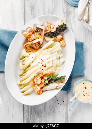 Asparagi con salmone, baccalà, gamberi e salsa hollandaise Foto Stock