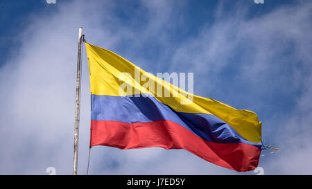 Sventola bandiera colombiana su un cielo blu - Bogotà, Colombia Foto Stock