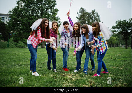 Sei ragazze a camicie a scacchi bevendo champagne sul partito di gallina. Un gruppo di ragazze felici. Foto Stock