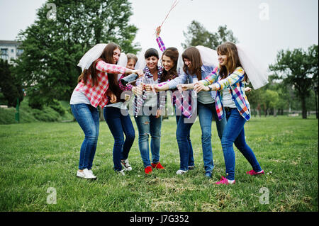 Sei ragazze a camicie a scacchi bevendo champagne sul partito di gallina. Un gruppo di ragazze felici. Foto Stock