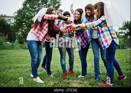 Sei ragazze a camicie a scacchi bevendo champagne sul partito di gallina. Un gruppo di ragazze felici. Foto Stock