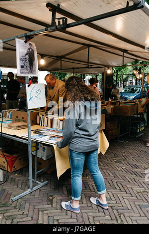 Hague, Paesi Bassi - 7 agosto 2016: le persone non identificate in un libro e mercato di antiquariato in stallo la strada dell'Aia Foto Stock