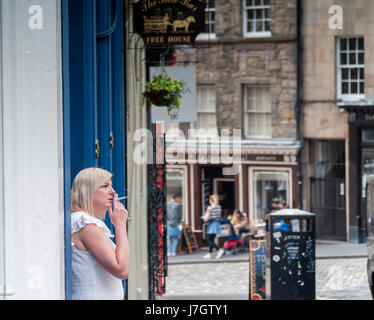 Una donna di fumare su un arco West Street di Edimburgo in Scozia Foto Stock