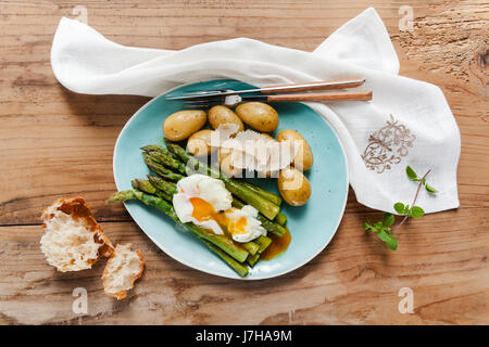 Molla leggera il pranzo sulla piastra. Asparagi Fritti, patate fresche e Uovo affogato con formaggio parmigiano. cibo sano. Foto Stock