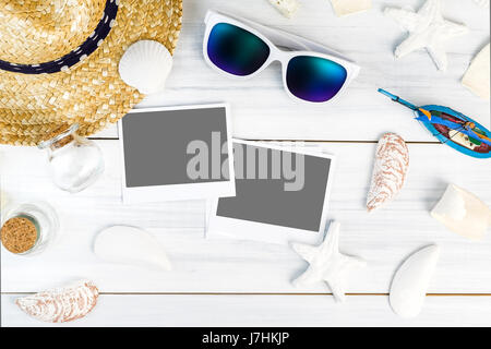 Estate spiaggia accessori (occhiali da sole bianco,starfish,cappello di paglia,shell) e photo frame su intonaco bianco tavola di legno vista dall'alto,vacanze estive concetto,Leav Foto Stock