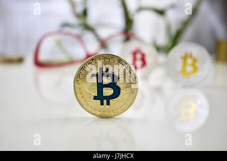 Valuta digitale fisico bitcoin colorati delle monete in euro nei pressi di rosa bicchieri Foto Stock