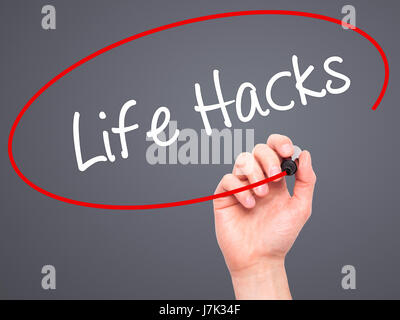 Man mano che scrive la vita Hack con pennarello nero su schermo visivo. Isolato su sfondo. Business, tecnologia internet concetto. Stock Photo Foto Stock