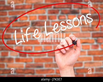 Man mano che scrive le lezioni di vita con pennarello nero su schermo visivo. Isolato su mattoni. Business, tecnologia internet concetto. Stock Photo Foto Stock