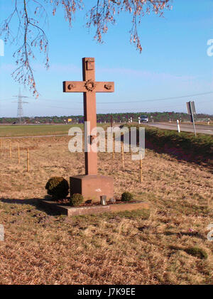 L'immagine "Wegkreuz Reilingen" raffigura una croce laterale situata a Reilingen, Germania. Le croci a lato della strada erano comunemente collocate lungo i fianchi della strada come segni di fede, fornendo ai pellegrini luoghi in cui pregare o riflettere. Foto Stock