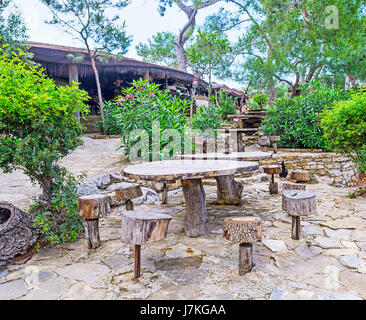 Il design rustico di tavolo in legno e sedie nel parco Yoruk a Kemer, Turchia. Foto Stock