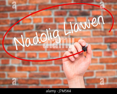 Man mano che scrive Nadolig Llawen (Buon Natale in lingua gallese) con pennarello nero su schermo visivo. Isolato su sfondo. Business, tecnologia internet Foto Stock