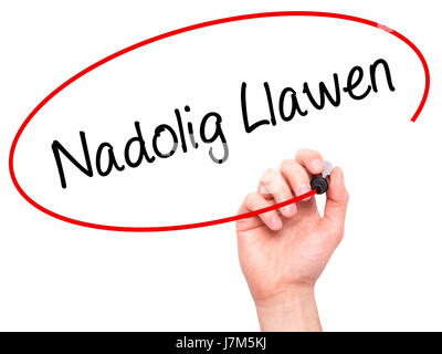 Man mano che scrive Nadolig Llawen (Buon Natale in lingua gallese) con pennarello nero su schermo visivo. Isolato su sfondo. Business, tecnologia internet Foto Stock