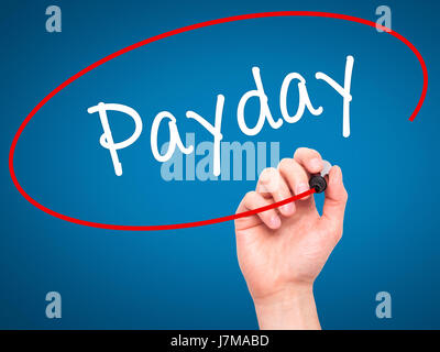 Man mano che scrive Payday con pennarello nero su schermo visivo. Isolato su blu. Business, tecnologia internet concetto. Stock Photo Foto Stock