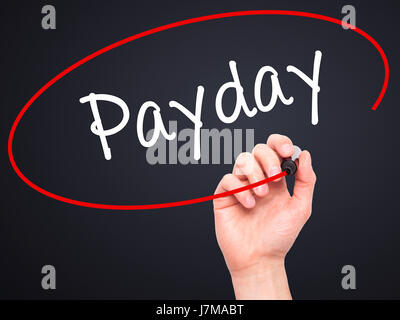 Man mano che scrive Payday con pennarello nero su schermo visivo. Isolato su nero. Business, tecnologia internet concetto. Stock Photo Foto Stock