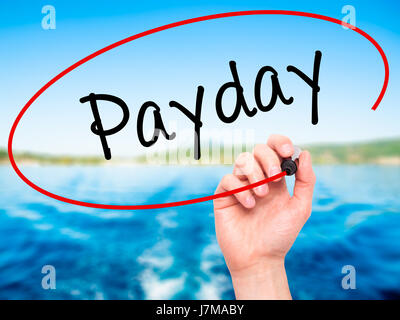 Man mano che scrive Payday con pennarello nero su schermo visivo. Isolato sulla natura. Business, tecnologia internet concetto. Stock Photo Foto Stock