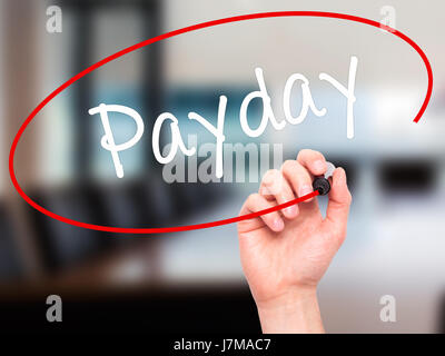 Man mano che scrive Payday con pennarello nero su schermo visivo. Isolato su office. Business, tecnologia internet concetto. Stock Photo Foto Stock