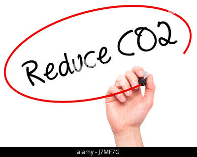 Man mano che scrive di ridurre le emissioni di CO2 con pennarello nero su schermo visivo. Isolato su sfondo. Business, tecnologia internet concetto. Stock Photo Foto Stock