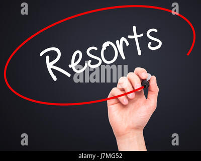 Man mano che scrive Resorts con pennarello nero su schermo visivo. Isolato su sfondo. Business, tecnologia internet concetto. Stock Photo Foto Stock