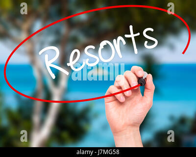 Man mano che scrive Resorts con pennarello nero su schermo visivo. Isolato su sfondo. Business, tecnologia internet concetto. Stock Photo Foto Stock