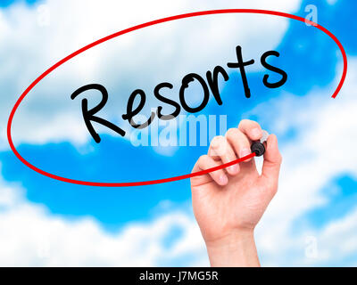 Man mano che scrive Resorts con pennarello nero su schermo visivo. Isolato su sfondo. Business, tecnologia internet concetto. Stock Photo Foto Stock