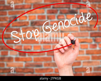 Man mano la scrittura di fermare il genocidio con pennarello nero su schermo visivo. Isolato su sfondo. Business, tecnologia internet concetto. Stock Photo Foto Stock