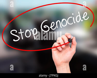 Man mano la scrittura di fermare il genocidio con pennarello nero su schermo visivo. Isolato su sfondo. Business, tecnologia internet concetto. Stock Photo Foto Stock