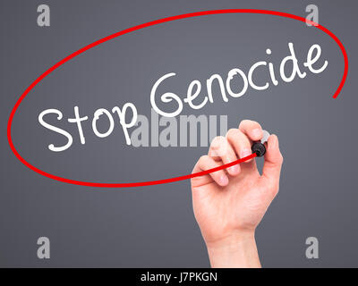 Man mano la scrittura di fermare il genocidio con pennarello nero su schermo visivo. Isolato su sfondo. Business, tecnologia internet concetto. Stock Photo Foto Stock