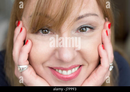 Ritratto di una donna matura, 45 anni, closeup, guardando la telecamera, sorridente, home background. Foto Stock