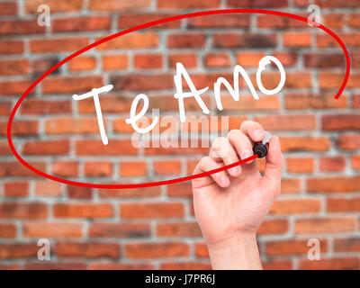 Man mano che scrive Te Amo ( ti amo in spagnolo) con pennarello nero su schermo visivo. Isolato su mattoni. Business, tecnologia internet concetto. Stoc Foto Stock