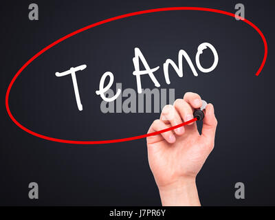 Man mano che scrive Te Amo ( ti amo in spagnolo) con pennarello nero su schermo visivo. Isolato su nero. Business, tecnologia internet concetto. Magazzino Foto Stock