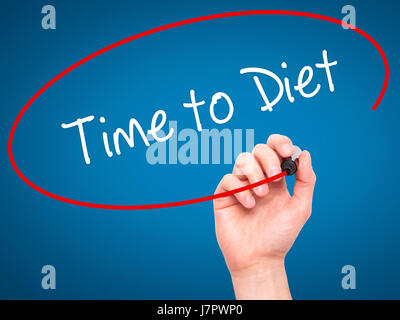 Man mano che scrive il tempo di dieta con pennarello nero su schermo visivo. Isolato su blu. Business, tecnologia internet concetto. Foto Stock