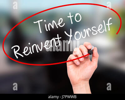 Man mano che scrive il tempo di reinventarsi con pennarello nero su schermo visivo. Isolato su office. Business, tecnologia internet concetto. Stock Photo Foto Stock