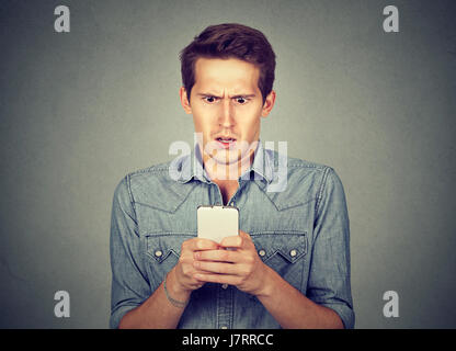 Scioccato uomo controllando il suo telefono cellulare Foto Stock