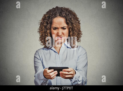 Closeup ritratto sconvolto triste scettico infelice donna gravi parlando texting sul telefono orinato disgustato con isolati di conversazione muro grigio backgrou Foto Stock