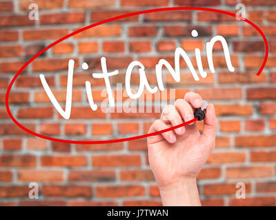 Man mano che scrive la vitamina con pennarello nero su schermo visivo. Isolato su mattoni. Business, tecnologia internet concetto. Stock Photo Foto Stock