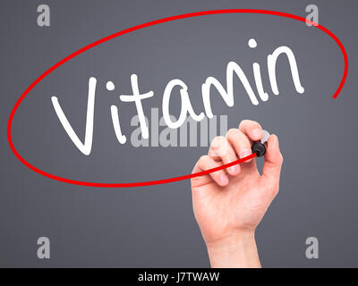 Man mano che scrive la vitamina con pennarello nero su schermo visivo. Isolato su grigio. Business, tecnologia internet concetto. Stock Photo Foto Stock