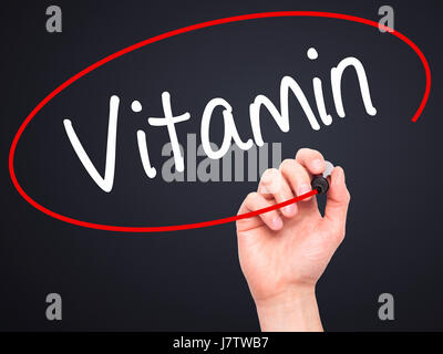 Man mano che scrive la vitamina con pennarello nero su schermo visivo. Isolato su nero. Business, tecnologia internet concetto. Stock Photo Foto Stock