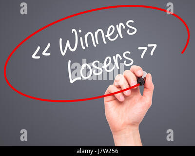 Man mano che scrive i vincitori - vinti con pennarello nero su schermo visivo. Isolato su sfondo. Business, tecnologia internet concetto. Stock Photo Foto Stock