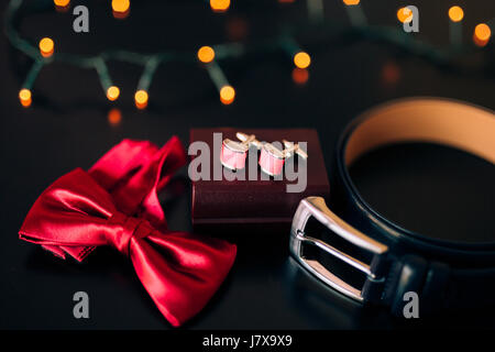 Nero scarpe dello sposo, rosso il filtro bow tie, gemelli, la cintura su un bla Foto Stock