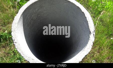 Tubo di cemento che sporgono dal terreno Foto Stock