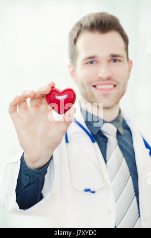 Medico tiene un cuore modello sagomato nella sua mano. medico cuore tenendo la salute healthcare sfondo bianco concetto maschio Foto Stock