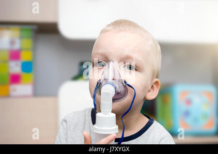 Bambino rendendo inalazione con maschera sul suo volto. Problemi di asma concept Foto Stock