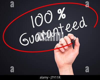Man mano che scrive il 100% garantito con marcatore sul panno trasparente stampato. Isolato su nero. Business, internet, concetto tecnologico. Stock Photo Foto Stock