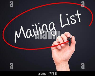 Man mano che scrive Mailing List con marcatore sul panno trasparente stampato. Isolato su nero. Business, internet, concetto tecnologico. Stock Photo Foto Stock